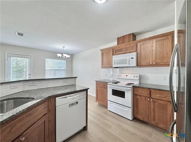 a kitchen with stainless steel appliances granite countertop a stove and a sink