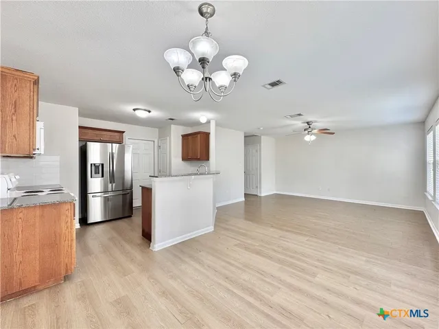 a view of a kitchen with a sink a microwave and cabinets