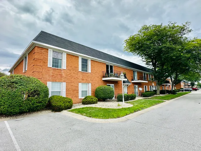 a front view of a house with a yard and trees