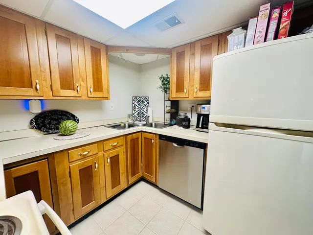 a kitchen with stainless steel appliances granite countertop wooden cabinets a sink and a window