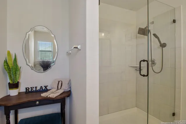 a bathroom with a sink a mirror a vanity and shower