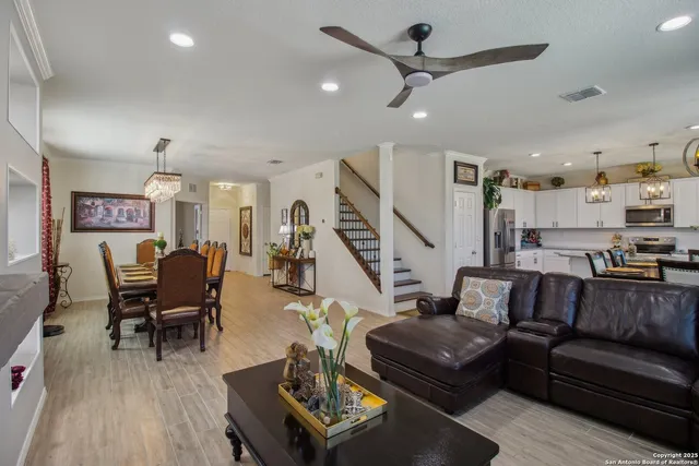 a living room with furniture kitchen view and a wooden floor