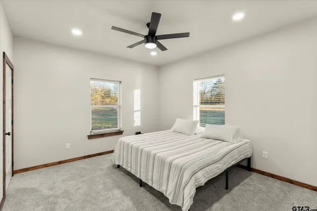 a bedroom with a large bed and a chandelier