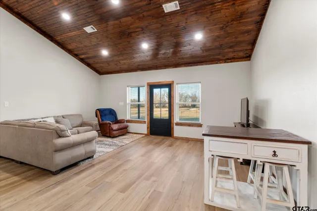 a living room with stainless steel appliances granite countertop furniture wooden floor and a view of kitchen