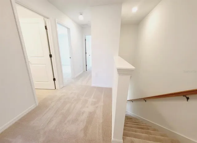 a view of a hallway with white walls and entryway