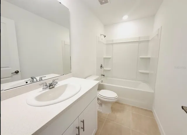 a bathroom with a sink a toilet a mirror a bathtub and shower