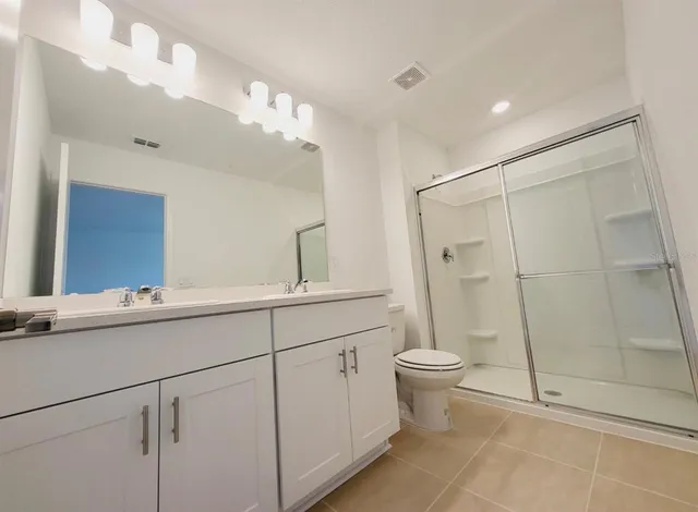 a bathroom with a double vanity sink mirror and toilet