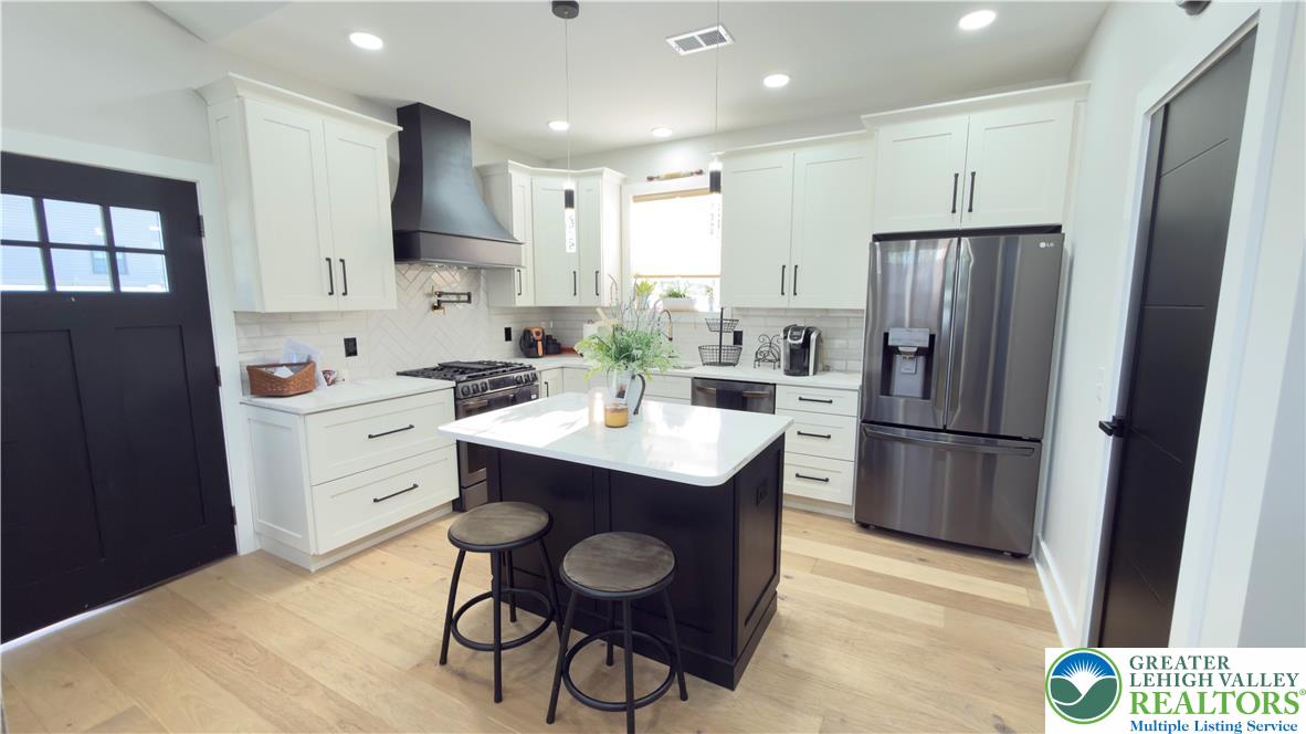 1425 Howertown Road, Unit B Catasauqua, PA 18032 - Photo 7 of 30 a kitchen with a sink a refrigerator a stove a microwave and island with wooden floor