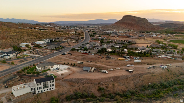 2591 East Washington Dam Road Washington, UT 84780 - Photo 59 of 67 Panoramic aerial perspective featuring a modern white-exterior structure with extensive windows, a paved driveway, and surrounding arid landscape