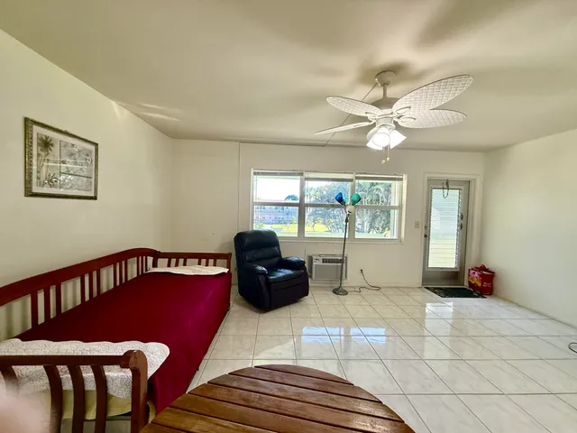 a view of a livingroom with furniture window and a ceiling fan