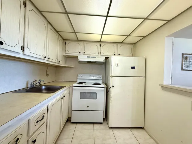 a kitchen with stainless steel appliances granite countertop a stove a refrigerator and a sink