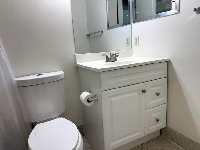 a bathroom with a sink mirror and toilet