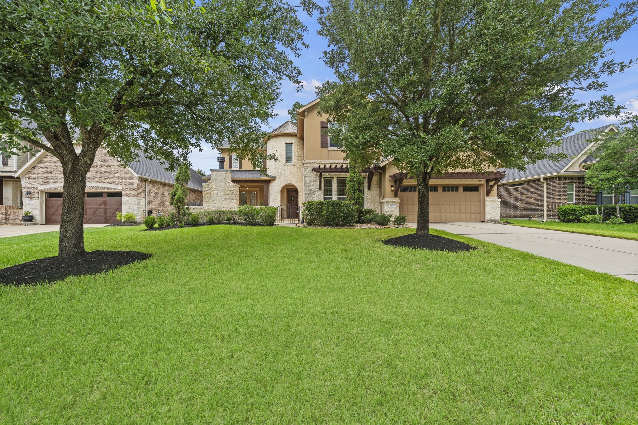 14215 Spindle Arbor Road Cypress, TX 77429 - Photo 43 of 47 This is a charming two-story home with a stone and stucco exterior, featuring a well-manicured lawn and mature trees. The property includes a spacious driveway leading to a two-car garage.