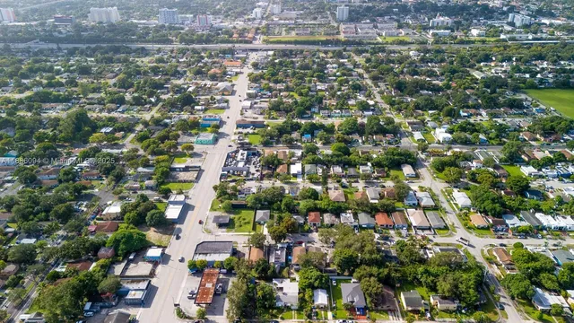 an aerial view of residential houses with outdoor space and trees