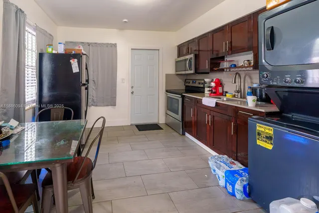 a kitchen with granite countertop a refrigerator and a stove top oven