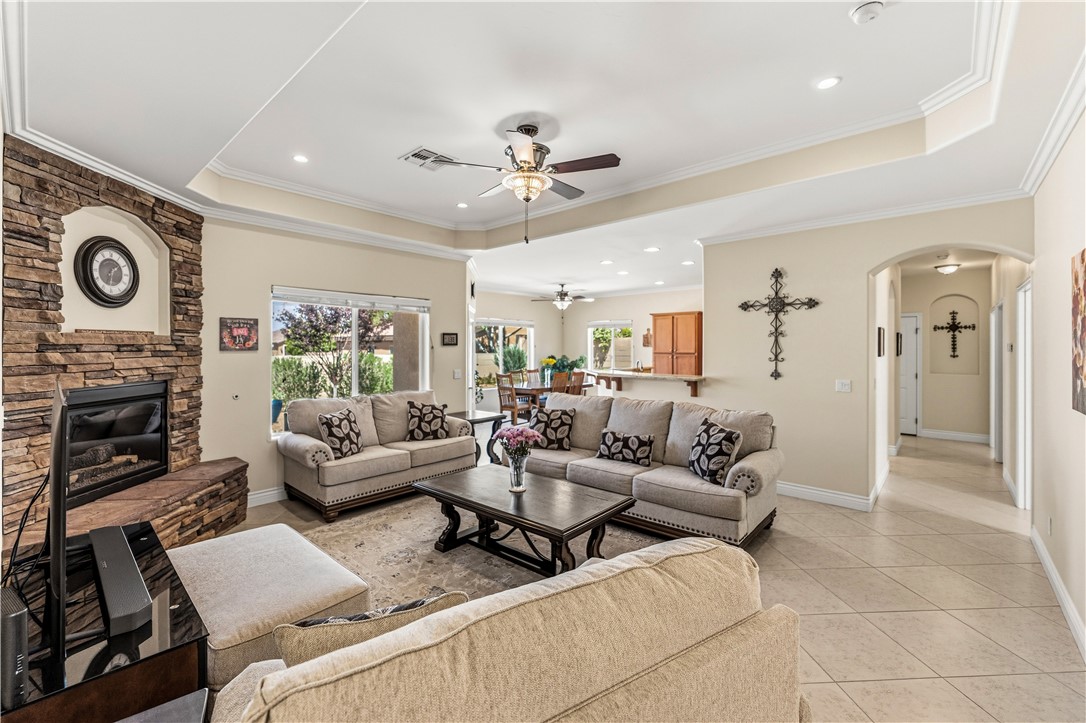 3315 Rainbow Mine Road Kingman, AZ 86401 - Photo 9 of 54 Spacious living area featuring a stone-clad fireplace, tray ceilings, and tile flooring
