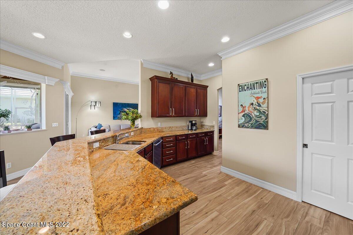245 Clyde Street Melbourne Beach, FL 32951 - Photo 12 of 47 a large kitchen with stainless steel appliances a large counter top a stove and a wooden floors