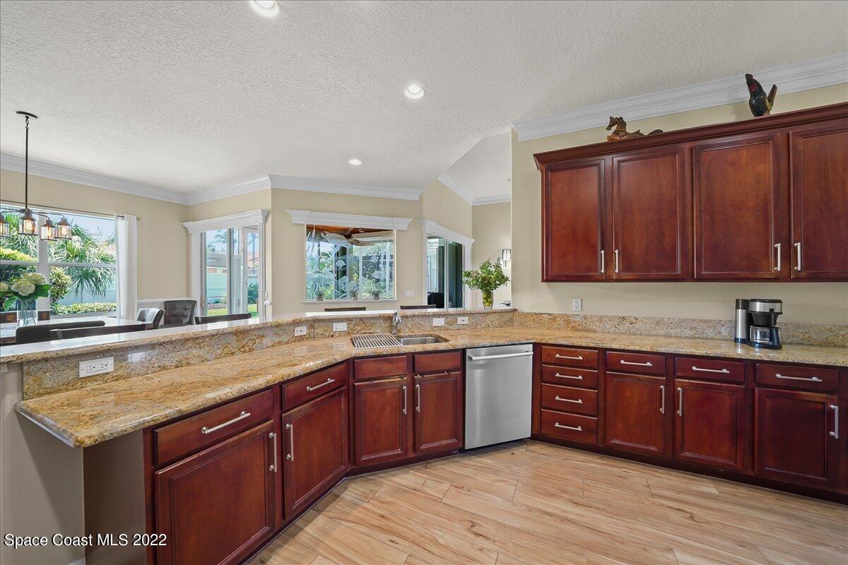 245 Clyde Street Melbourne Beach, FL 32951 - Photo 14 of 47 a kitchen with a sink and wooden cabinets