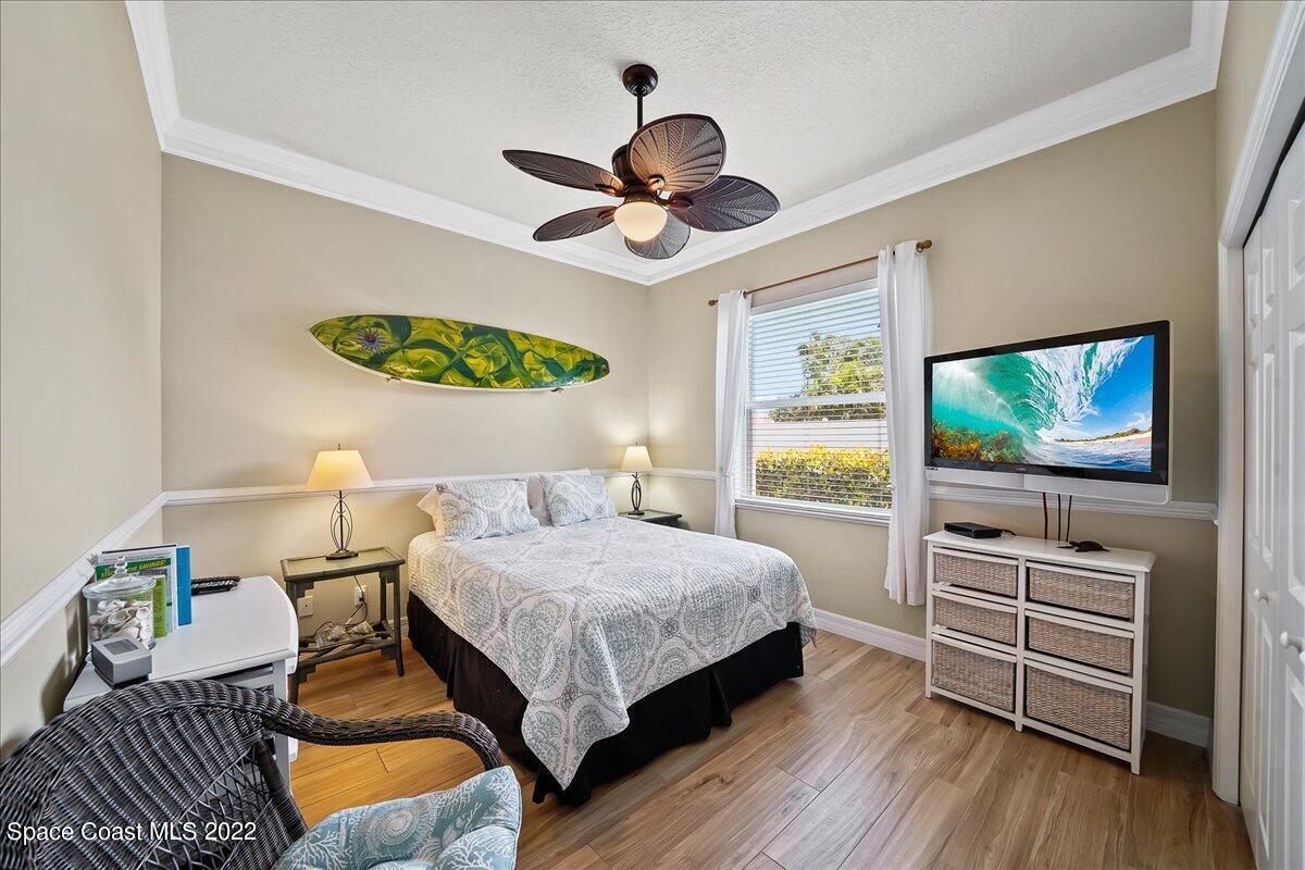 245 Clyde Street Melbourne Beach, FL 32951 - Photo 18 of 47 a bedroom with a bed and a flat screen tv
