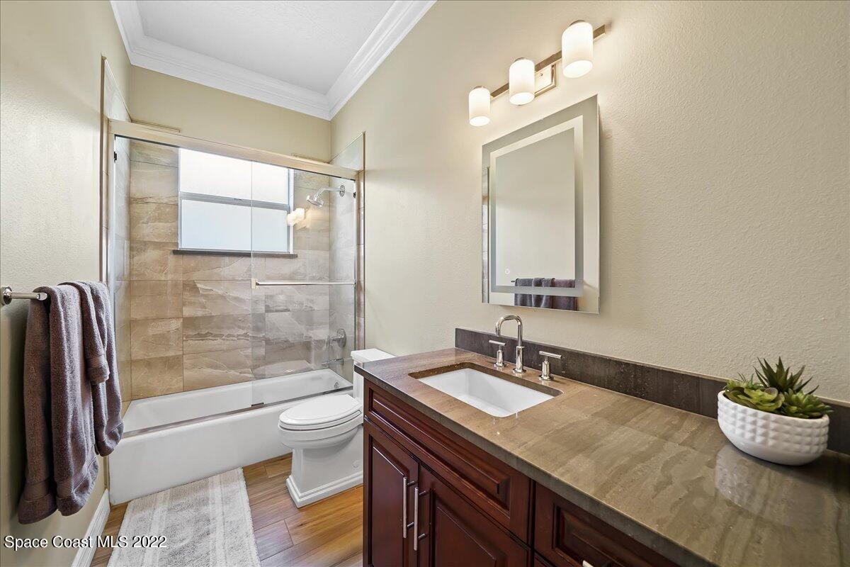 245 Clyde Street Melbourne Beach, FL 32951 - Photo 20 of 47 a bathroom with a granite countertop sink a toilet a mirror and shower