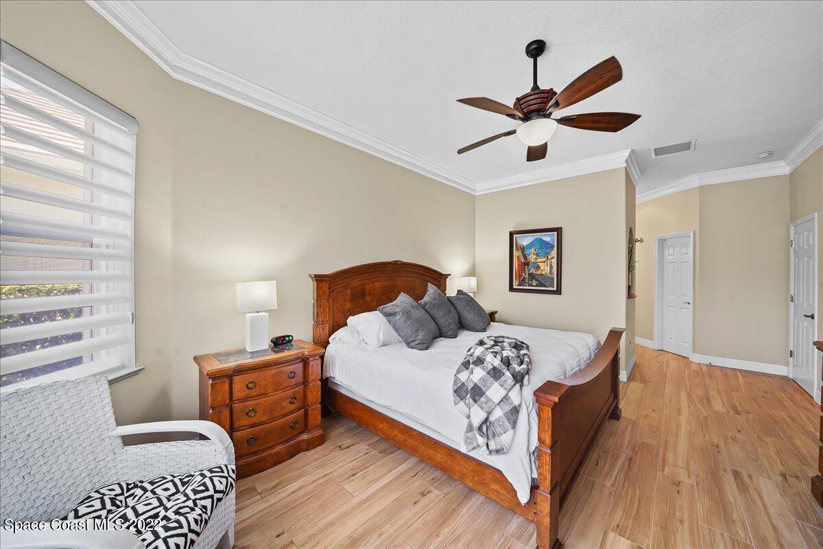 245 Clyde Street Melbourne Beach, FL 32951 - Photo 23 of 47 a bedroom with a bed and wooden floor