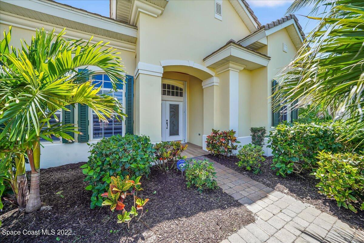 245 Clyde Street Melbourne Beach, FL 32951 - Photo 5 of 47 a front view of yellow house with a flower plants