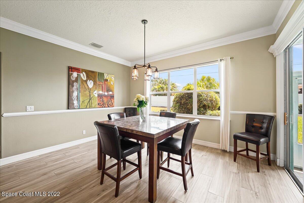245 Clyde Street Melbourne Beach, FL 32951 - Photo 9 of 47 a dining room with furniture a chandelier and wooden floor