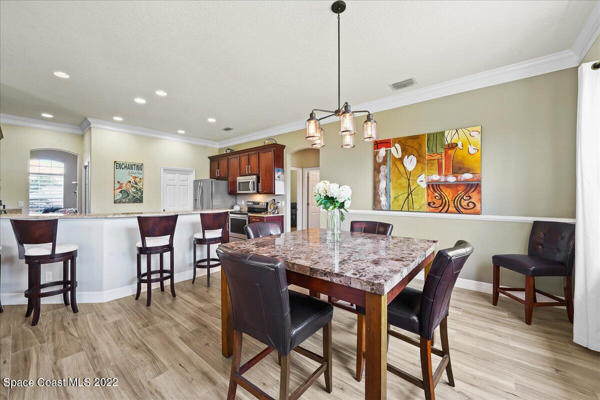 245 Clyde Street Melbourne Beach, FL 32951 - Photo 10 of 47 a dining room filled chandelier and wooden floor