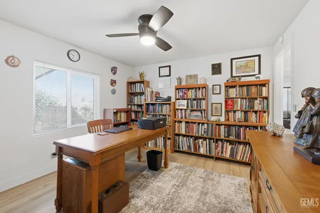 a view of a workspace with furniture and a window