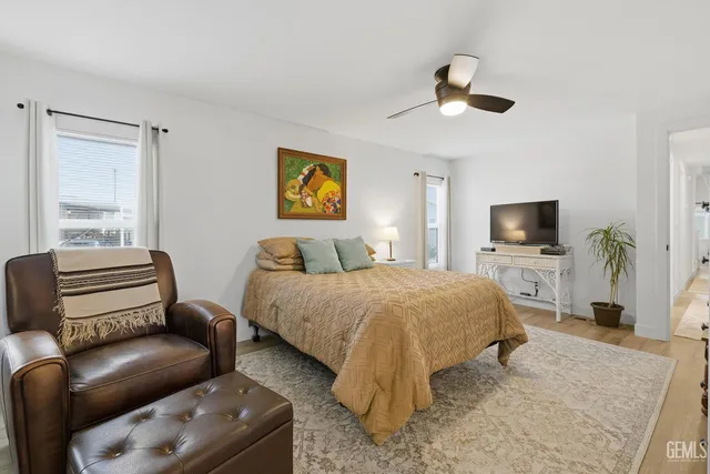 a bedroom with a bed a couch and a flat screen tv