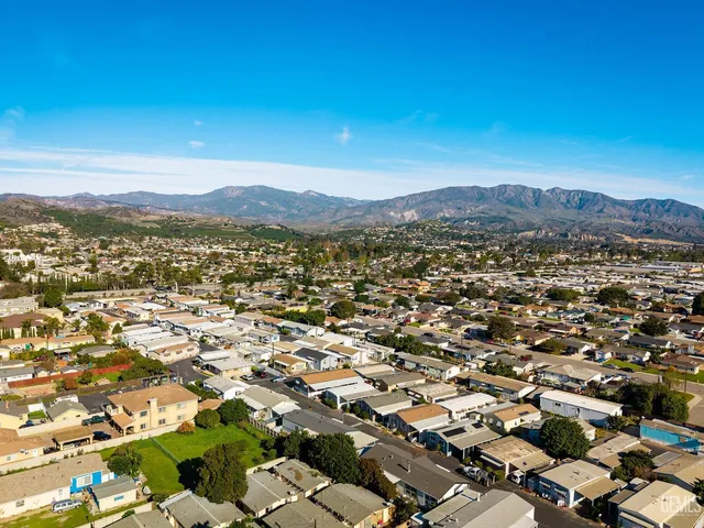 an aerial view of residential houses with outdoor space and river