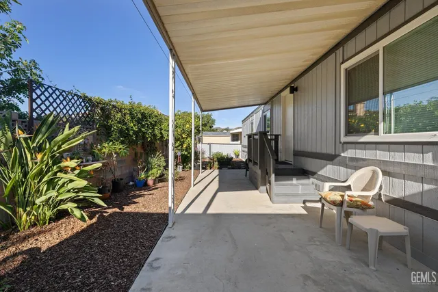 a view of a patio with table and chairs potted plants with wooden floor and fence