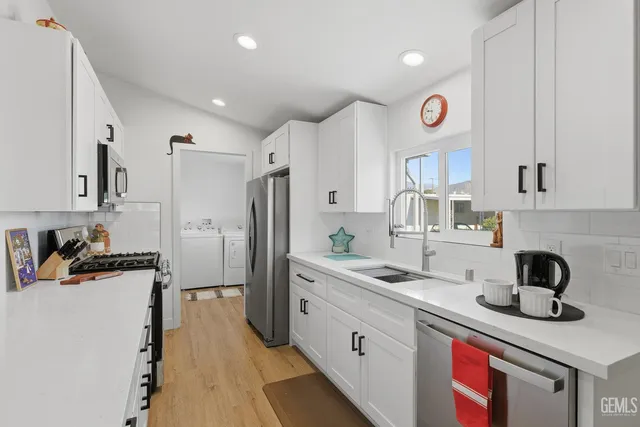 a kitchen with granite countertop a sink stove and refrigerator
