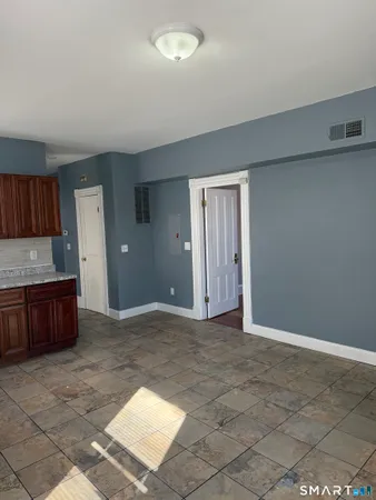 a view of an empty room and kitchen
