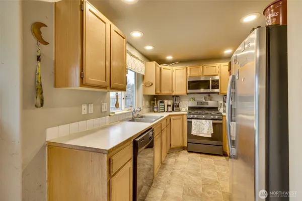 a kitchen with kitchen island granite countertop a sink appliances cabinets and furniture