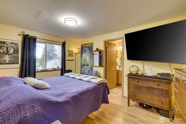 a bedroom with a bed and flat screen tv