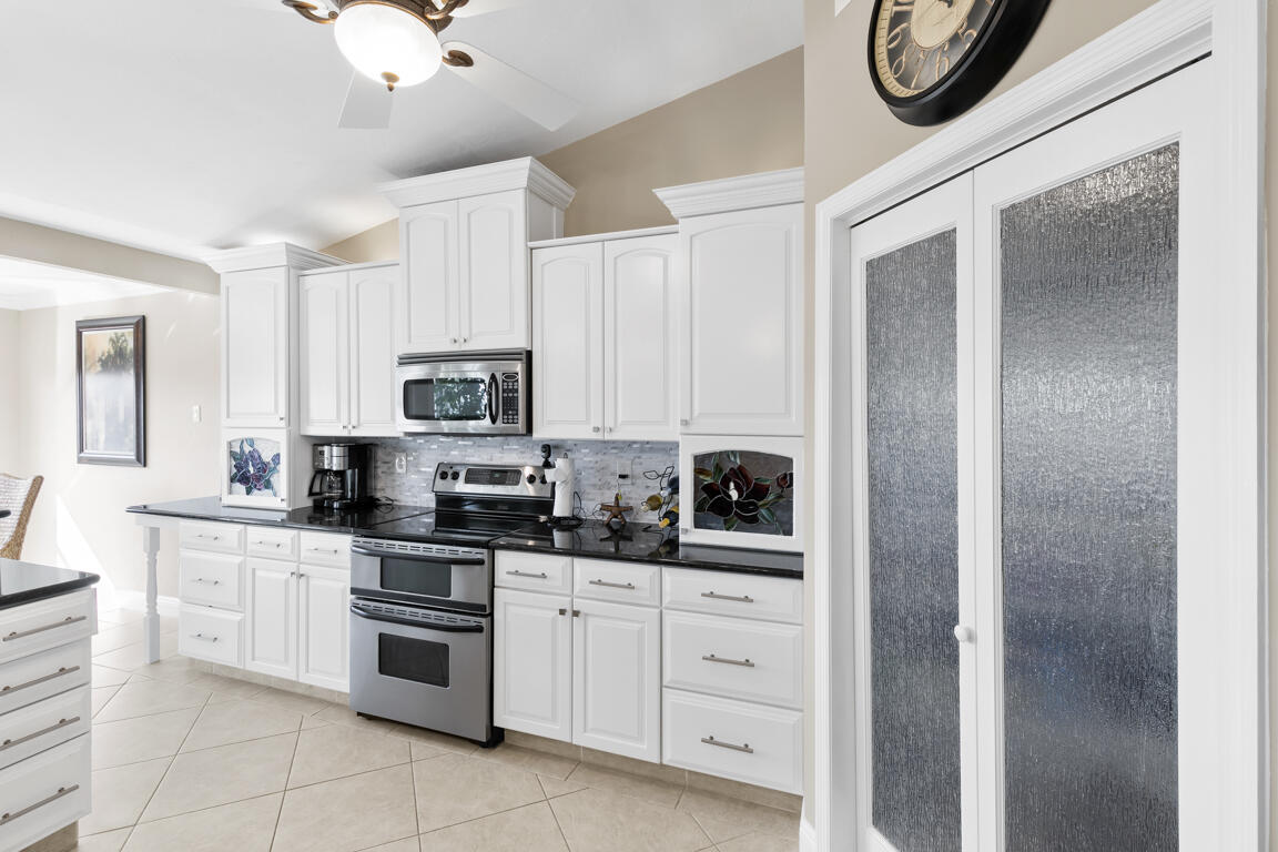 110 June Court Marco Island, FL 34145 - Photo 10 of 41 a kitchen with white cabinets and appliances