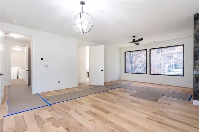 a view of an empty room with window and wooden floor