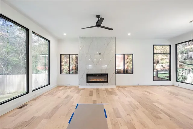 a view of an empty room with large windows and a fireplace
