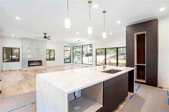a large kitchen with kitchen island a large window a sink and stainless steel appliances
