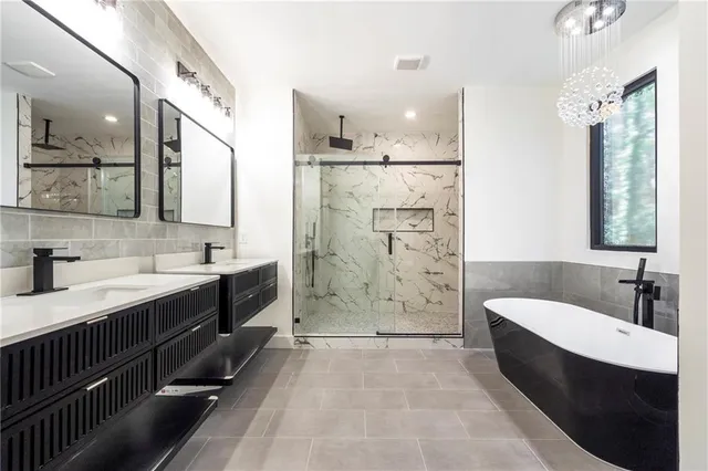 a spacious bathroom with a double vanity sink a mirror a bathtub and shower