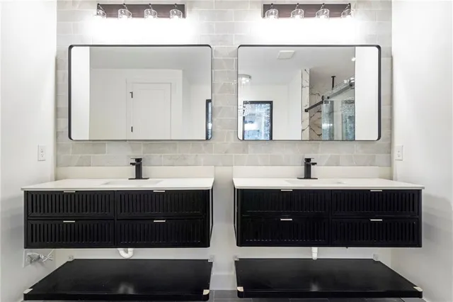a bathroom with double sink and two mirror