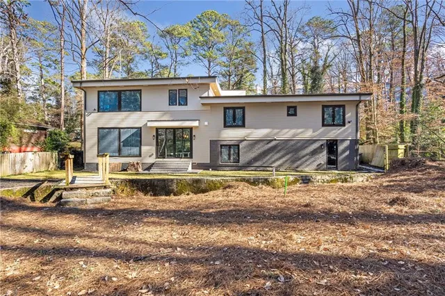 a view of a house with a yard chairs and floor to ceiling window