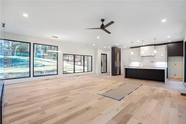 a view of an empty room with a window and a kitchen