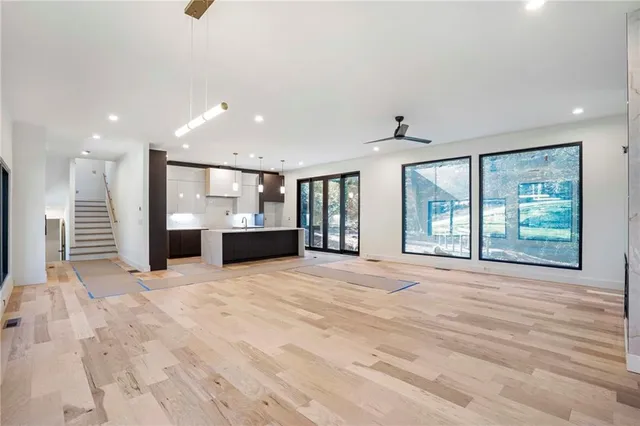 a view of an empty room with a window and a kitchen