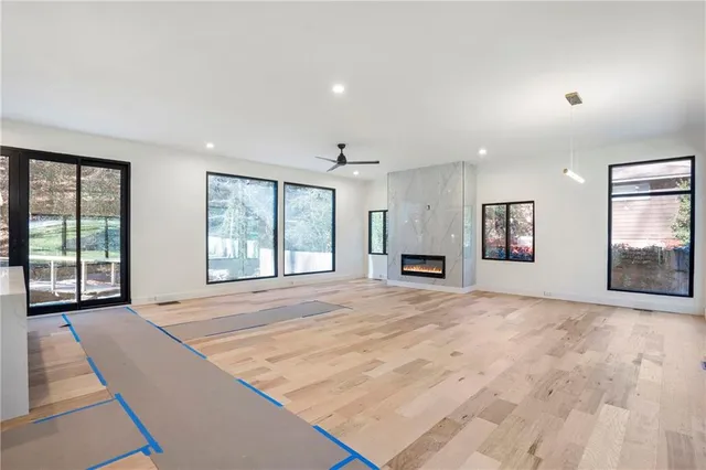 a view of an empty room with a window and a kitchen