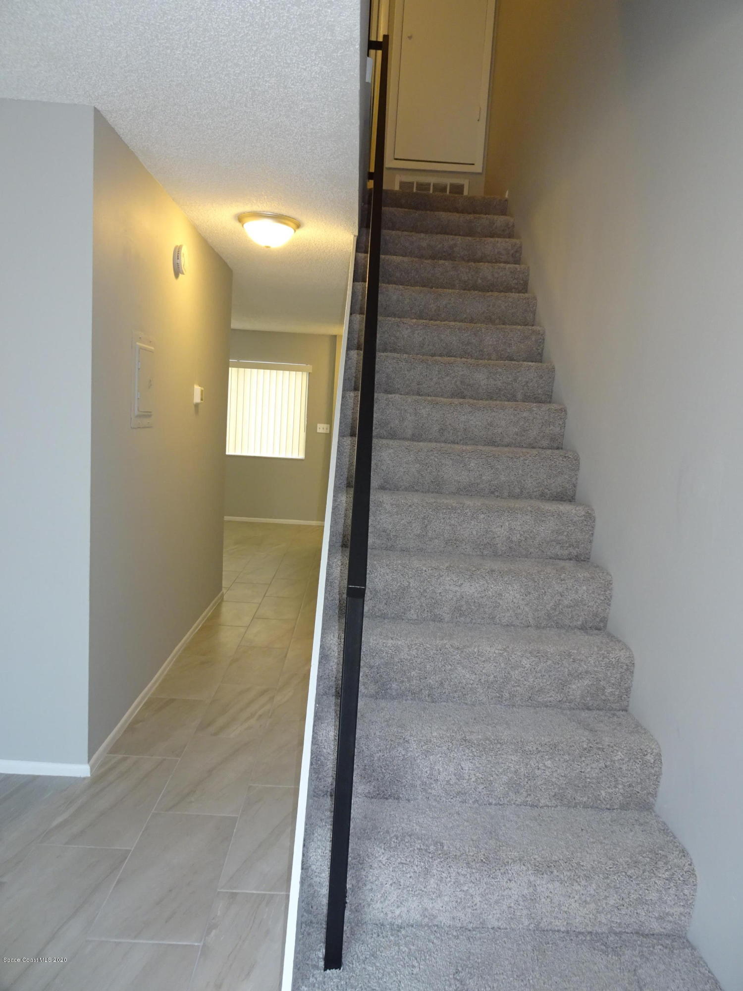 4875 Sisson Road Titusville, FL 32780 - Photo 6 of 14 a view of staircase with white walls and windows