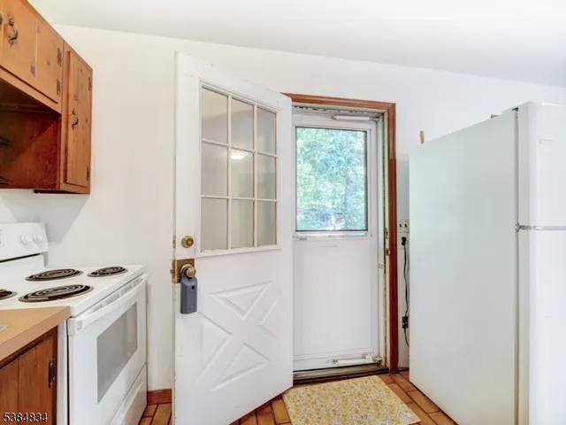 a view of kitchen with stainless steel appliances cabinets and a window
