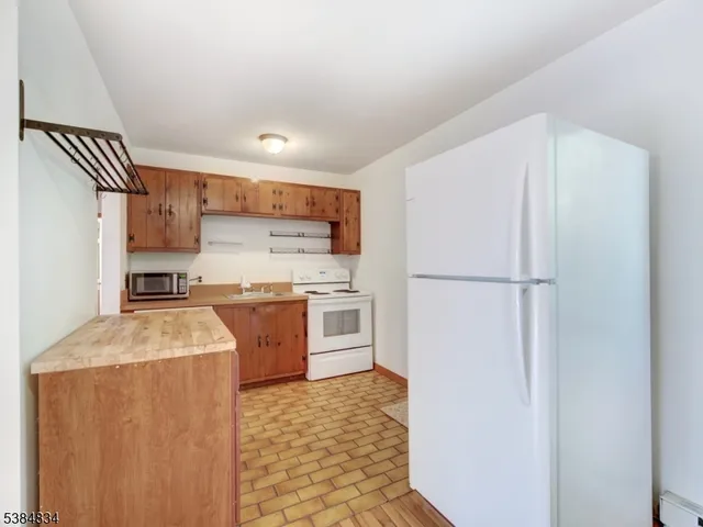 a kitchen with a refrigerator sink and cabinets