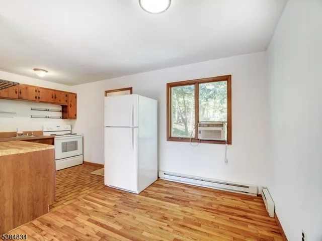 a view of a kitchen with wooden floor and electronic appliances